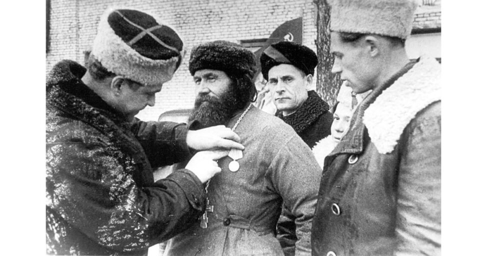 Командир 5 Ленинградской партизанской бригады К.Д. Карицкий вручает медаль отличившемуся партизану
